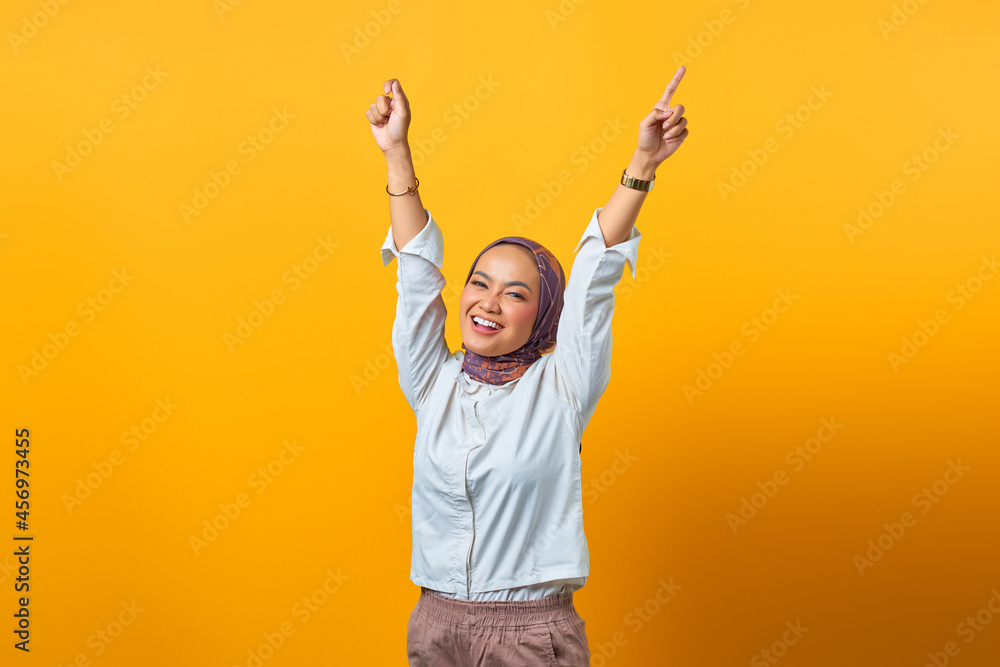 Portrait of cheerful Asian woman with victory expression over yellow background Portrait of cheerful Asian woman with victory expression over yellow background