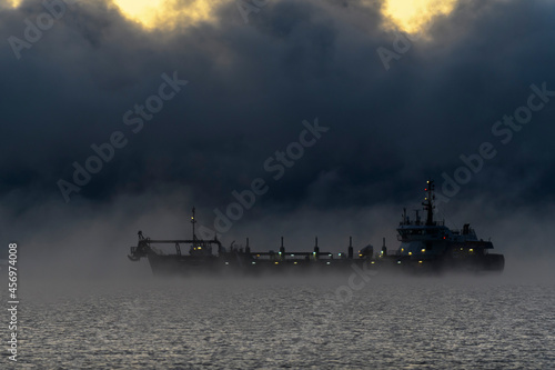 Vessel restricted in her ability to manoeuvre under way using engine at night time. Vessel engaged in dredging. Dredger working at sea. Collision regulations.