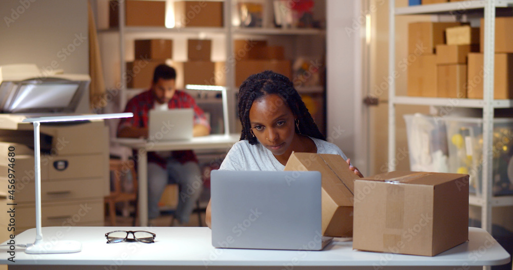 African female manager check address on parcel boxes working in warehouse African female manager check address on parcel boxes working in warehouse
