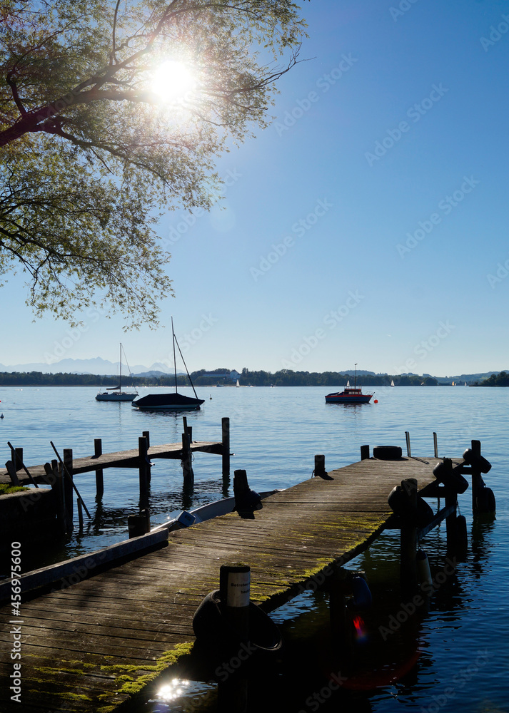 Φωτογραφία an old wooden pier on Island Frauenchiemsee on lake Chiemsee in Bavaria on a sun