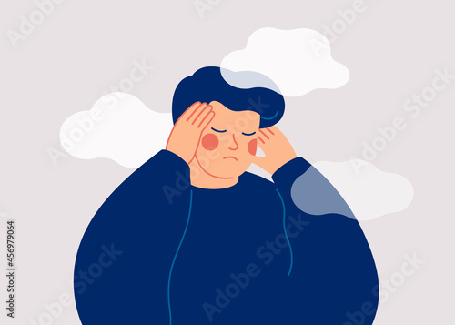 A sad young man has a clouded mind on blue background. A depressed teenager boy suffers from temporary memory loss and confusion. Vector illustration photo
