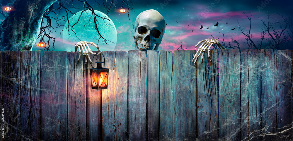 Fototapeta premium Halloween - Skeleton Holding Lantern On Wooden Banner In Night