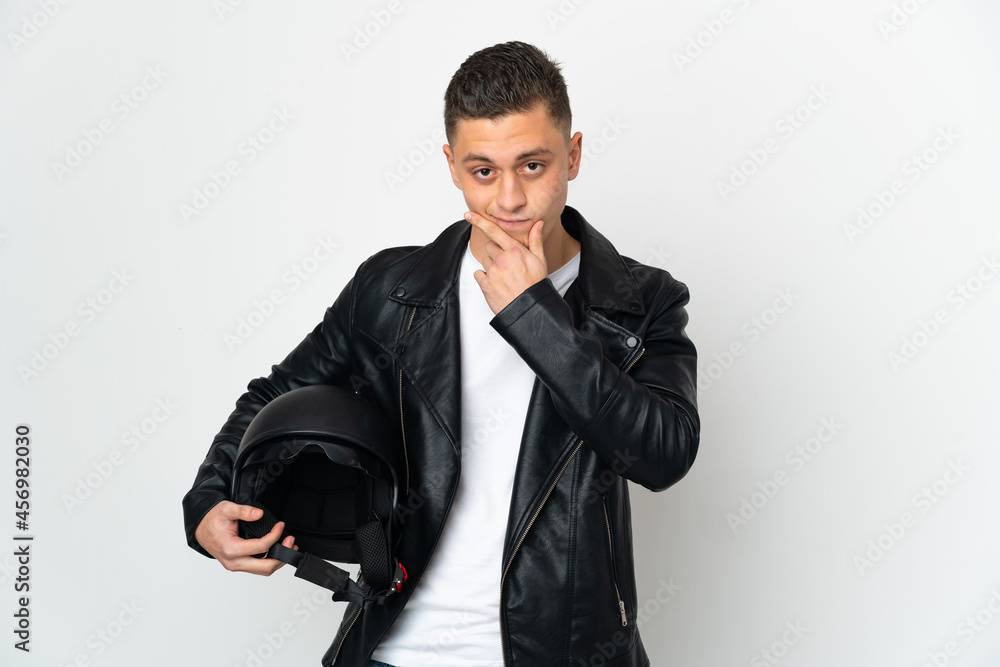 Caucasian man with a motorcycle helmet isolated on white background thinking Caucasian man with a motorcycle helmet isolated on white background thinking