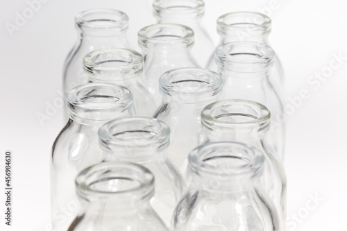 Kleine durchsichtige Glasflaschen vor weißem Hintergrund.