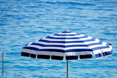 Fototapeta Photographie de plage, avec un ombrelle et la mer méditerranée, à Nice, Côte d'A