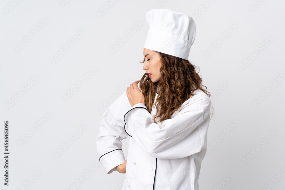 Young chef woman isolated on white background suffering from pain in shoulder for having made an effort Young chef woman isolated on white background suffering from pain in shoulder for having made an effort