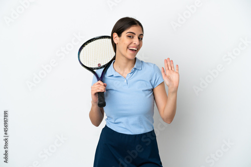 Handsome young tennis player caucasian woman isolated on white background saluting with hand with happy expression