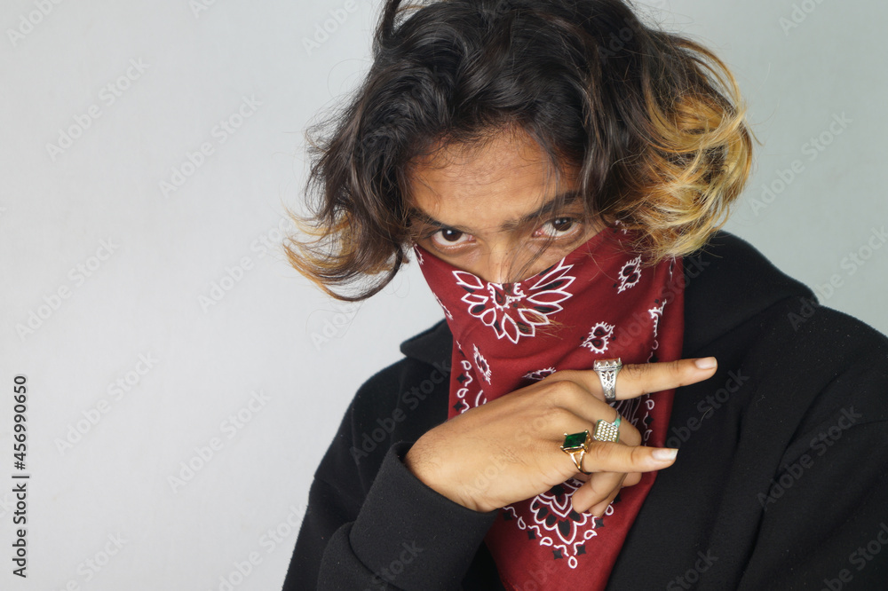 Young thug Indian male with a bandana covering his face and rings on his fingers doing gang