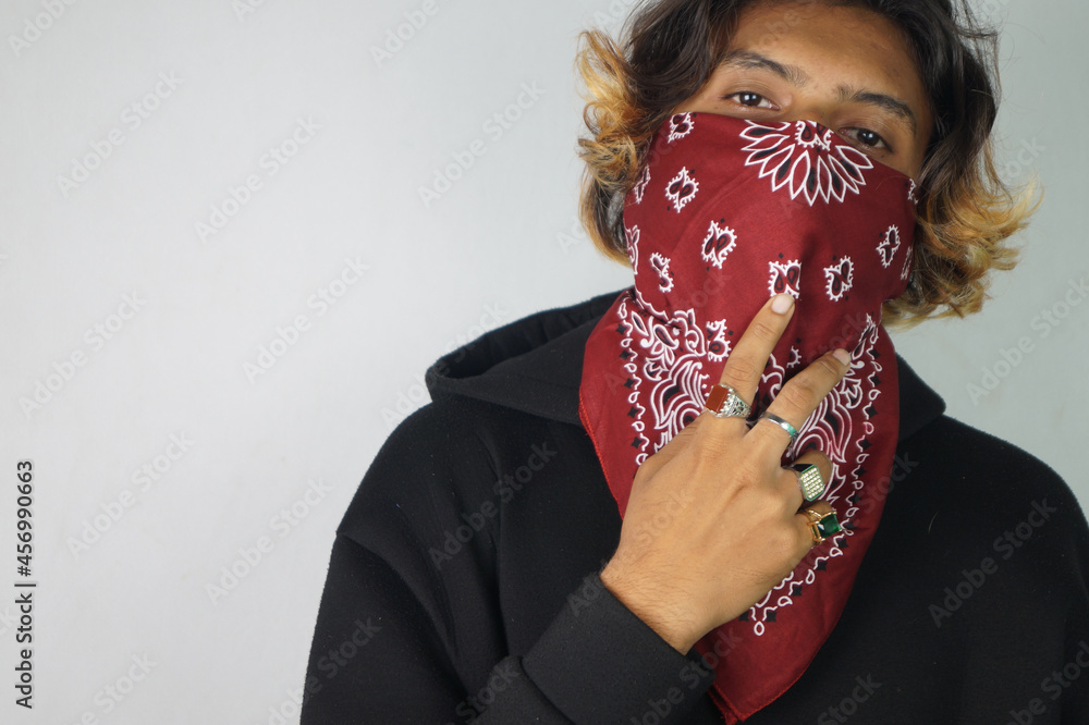 Young thug Indian male with a bandana covering his face and rings on his  fingers Stock Photo | Adobe Stock
