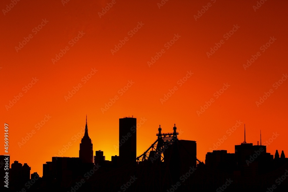 silhouette cityscape of Manhattan in city of New York, USA at dusk time with orange sky background and copy space on the top