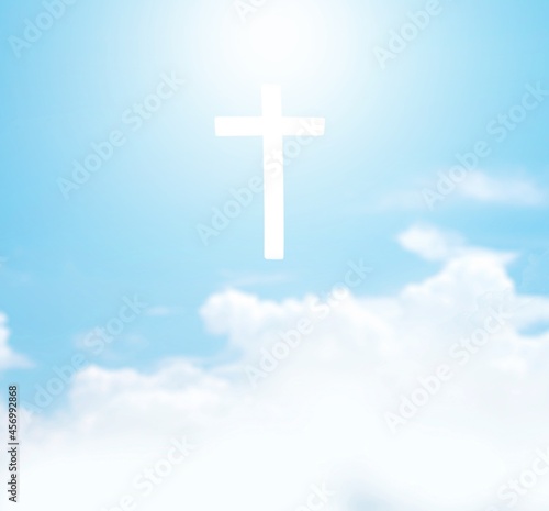 Christian cross appears bright in the sky background and clouds.