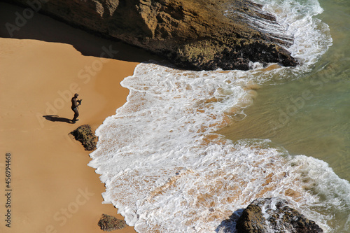A diver in special equipment for spearfishing is preparing to enter the ocean.