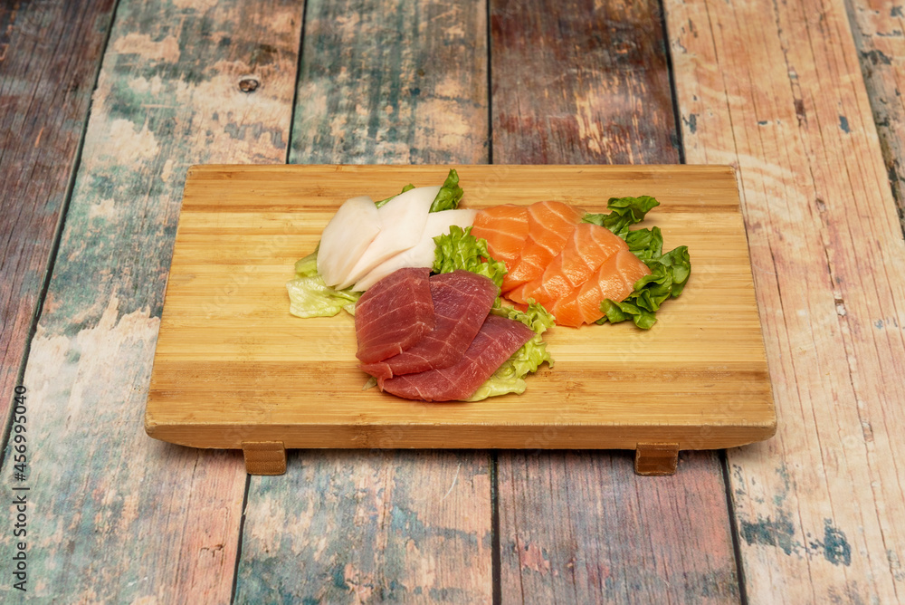 delicious and colorful sushi sashimi with Mediterranean red tuna, Norwegian salmon and butterfish on a bamboo board