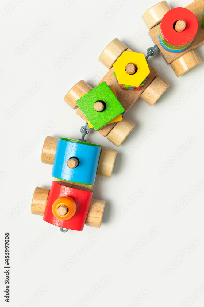 Obraz premium Wooden train with colored blocks on white background. Kids toys made of natural wood in rainbow colors. Eco friendly toy, game, plastic free. Toy for babies and toddlers. Flat lay