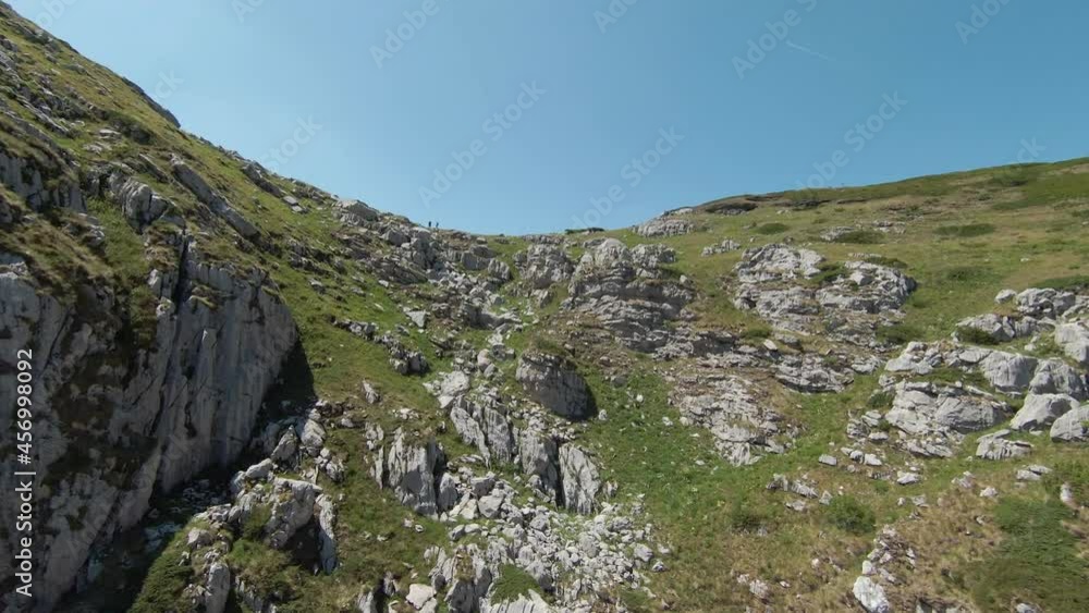 FPV drone flying up and over some hikers, opening mountain trail. Prokletije mountain, Montenegro. 