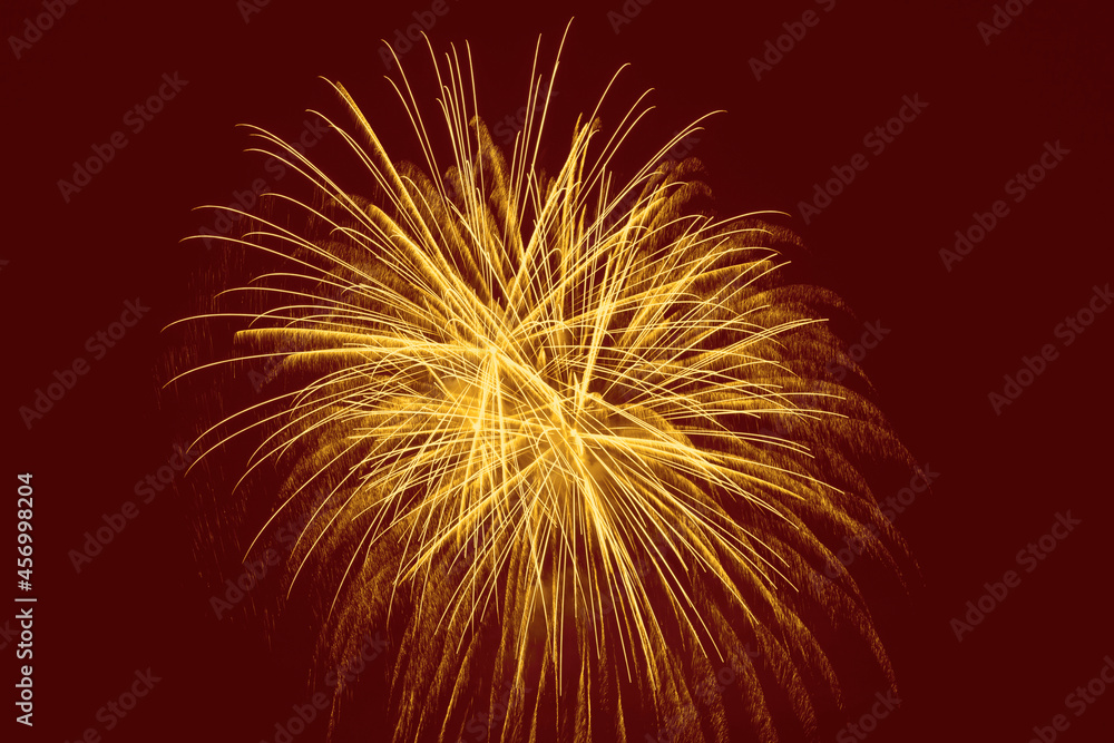 ellow fireworks against dark red background