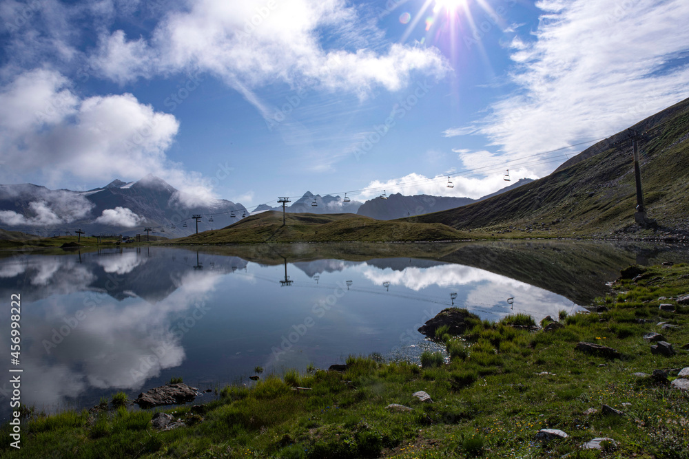 Obraz premium High altitude mountain landscape with the mountain reflected in a lake and a sunset