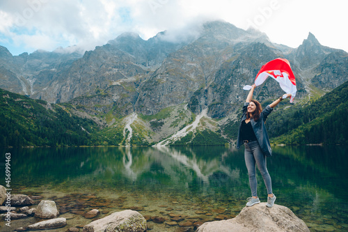 young pretty woman with poland flag in mountains near lake
