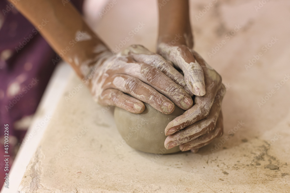 Female pottery artist preparing clay for molding. Close Up view of woman hands with clay. Creative handmade craft