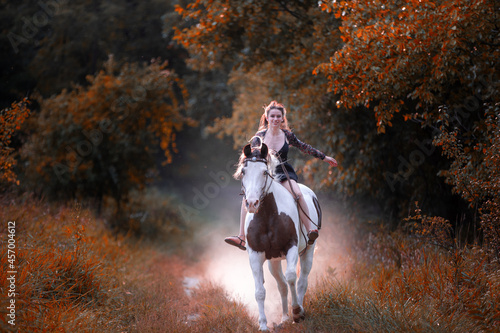 Image of a girl riding a horse in a forest during fall at sunset © Final Cut Images