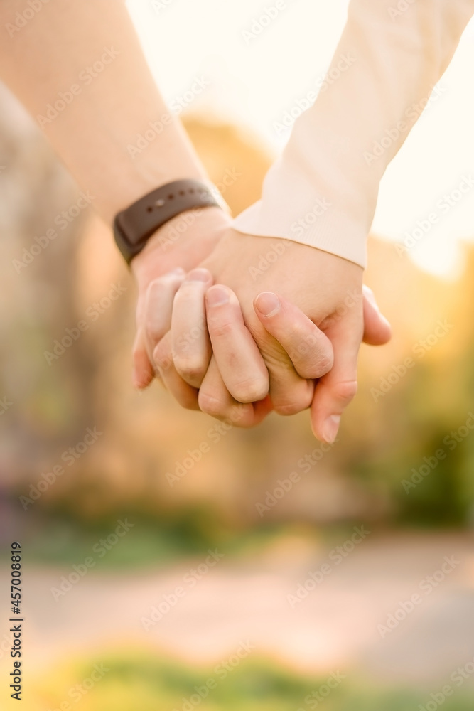 a guy and a girl are standing next to each other, holding hand by hand, vertical image.