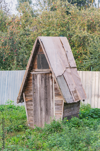 Wooden ancient toilet cabin by rthe private village house. photo