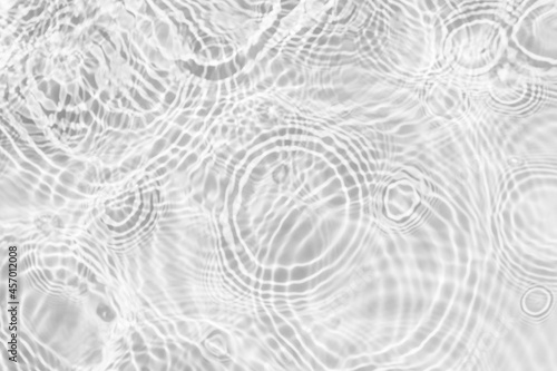 Water texture with circles on the water overlay effect for photo or mockup. Organic drop shadow caustic effect with wave refraction of light on a white or gray wall background. © esvetleishaya