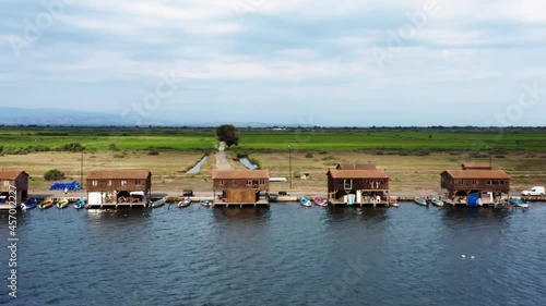 Panning aerial view of many fishermen huts at the national park of delta of Axios river, Greece. photo