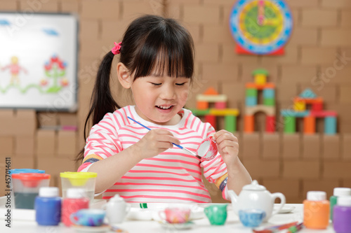 young girl painting tea set craft for homeschooling