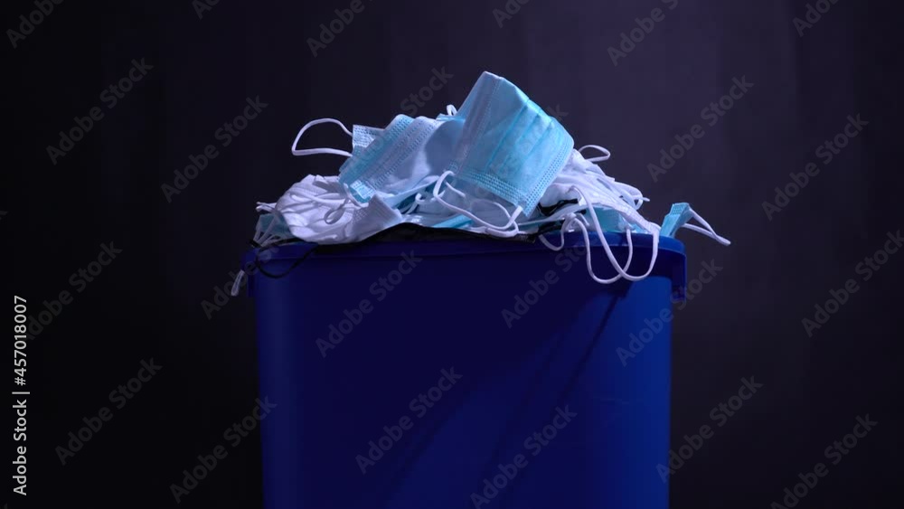 Medical masks in the recycle bin. Reusing and recycling of used