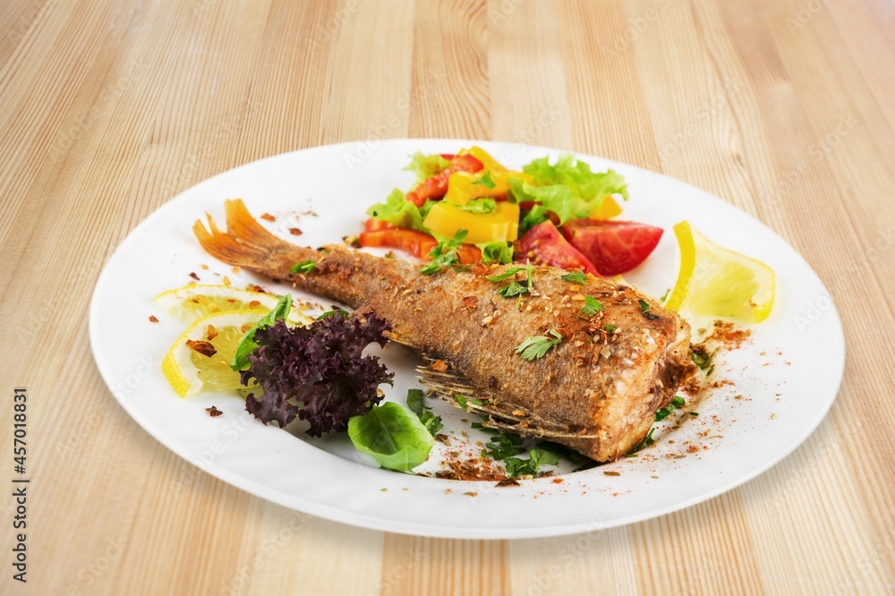 Traditional food tasty fish with vegetables on a plate Traditional food tasty fish with vegetables on a plate