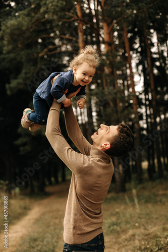 a young happy father throws his daughter in his arms