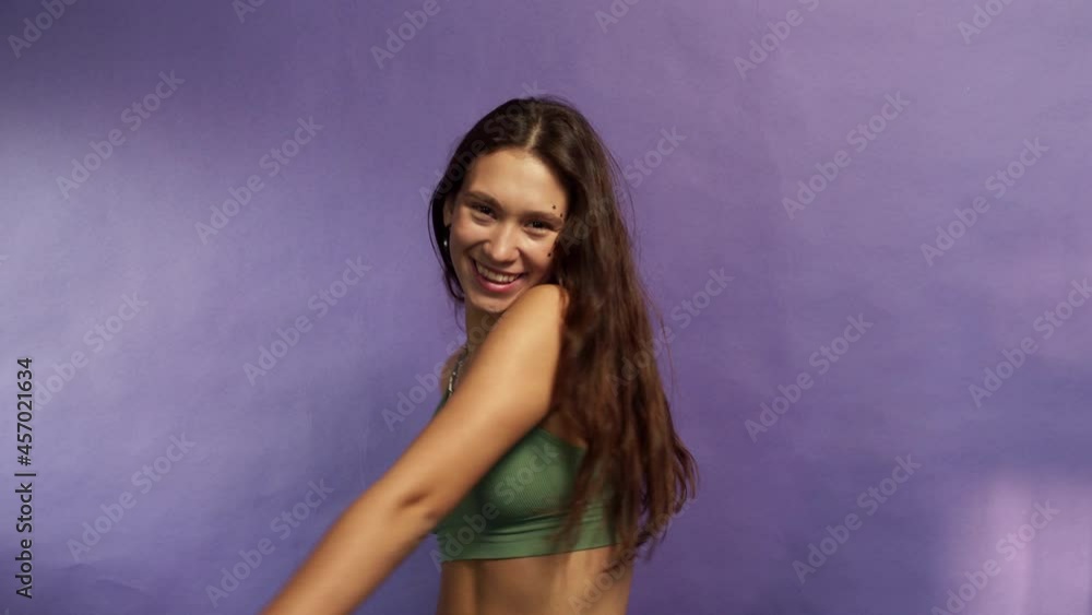 Smiling teenage brunette is dancing and jumping on a colorful background Smiling teenage brunette is dancing and jumping on a colorful background