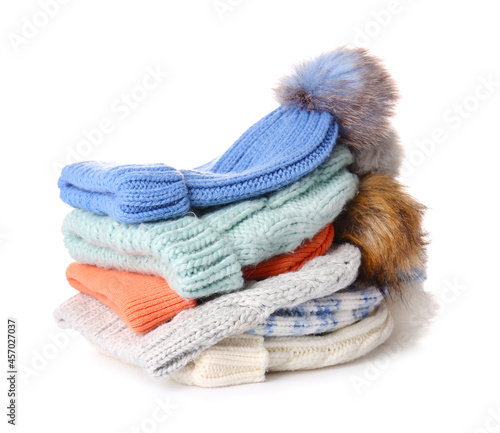 Stack of warm hats on white background