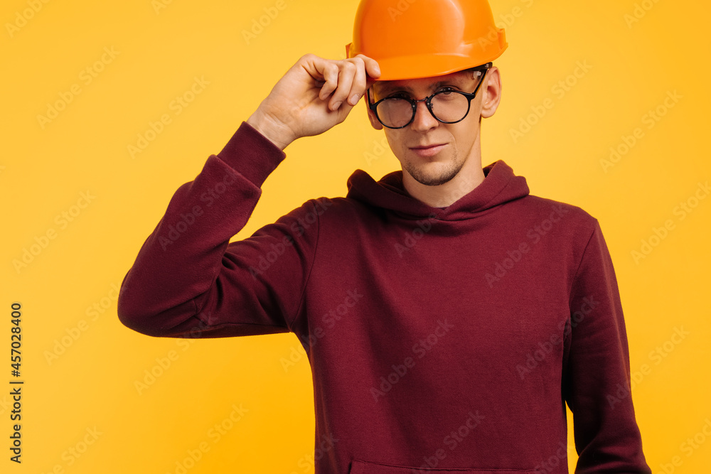 handsome man in construction helmet and glasses, young student builder, choice of profession for student handsome man in construction helmet and glasses, young student builder, choice of profession for student