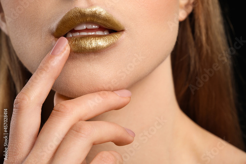 Beautiful young woman with golden makeup, closeup