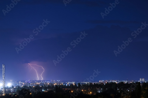 Dark sky with lightning over night city