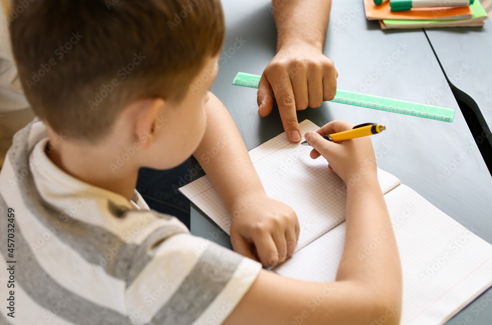Little boy with his father doing lessons at home, closeup Little boy with his father doing lessons at home, closeup