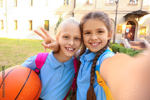 Cute little schoolgirls wit...