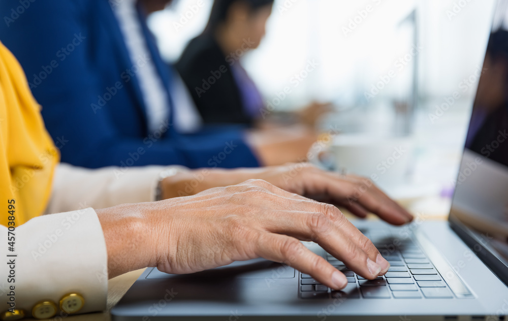 Selective focus on business woman's hands sitting and working on laptop on conference table in office. Concept for business meeting Selective focus on business woman's hands sitting and working on laptop on conference table in office. Concept for business meeting