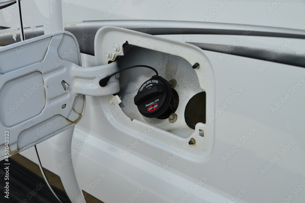 Fototapeta premium Vehicle fuel door open with gas cap in place.