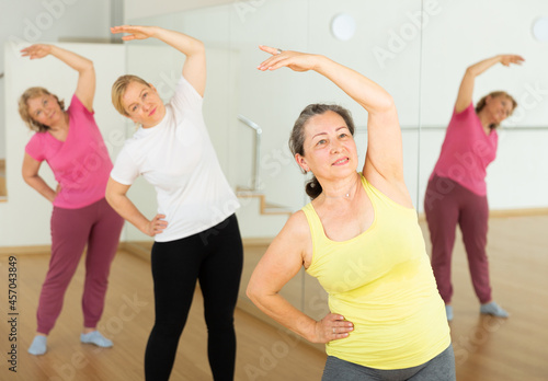 Three European mature women are dancing in fitness room