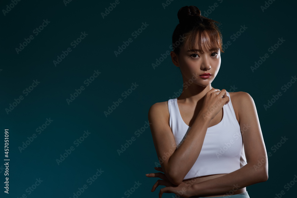 Obraz premium スポーツウェアを着た若い女性の陰影のあるポートレート