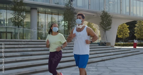 Young couple jogging with protective mask in city photo