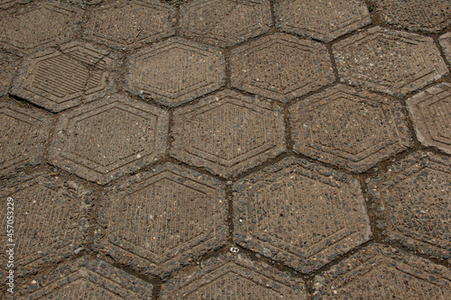 The texture of a sidewalk lined with hexagonal paving slabs.