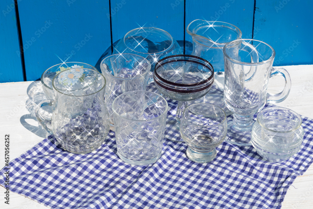 Washed, shiny glassware sits on a blue checkered napkin. Washed, shiny glassware sits on a blue checkered napkin.