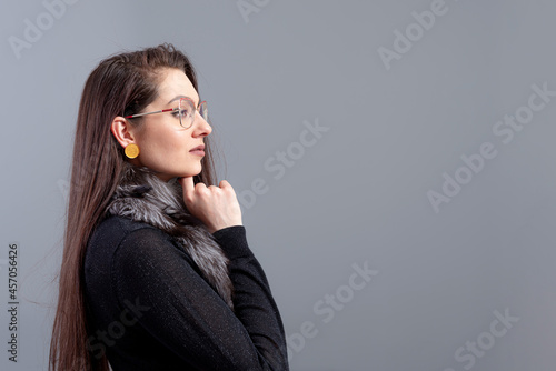 portrait of sensual woman in glasses with long hair against gray background