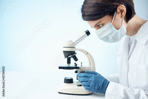 Woman in white coat microscope science work professionals