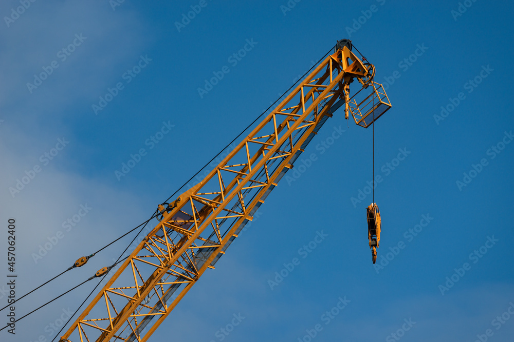 Industrial construction crane against a blue sky Industrial construction crane against a blue sky