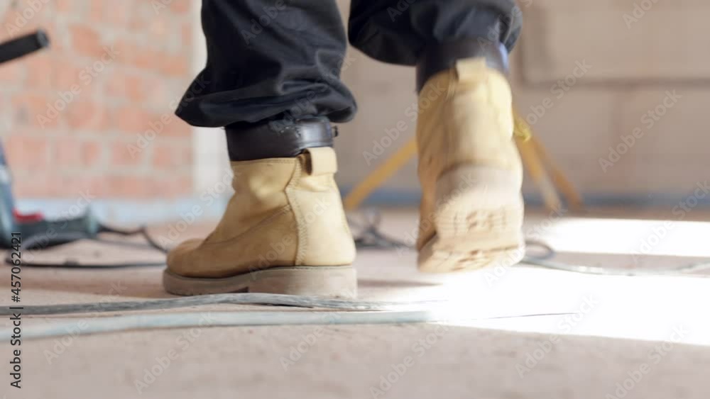 Close-up of a construction worker picks up a drill. Close-up of a construction worker picks up a drill.